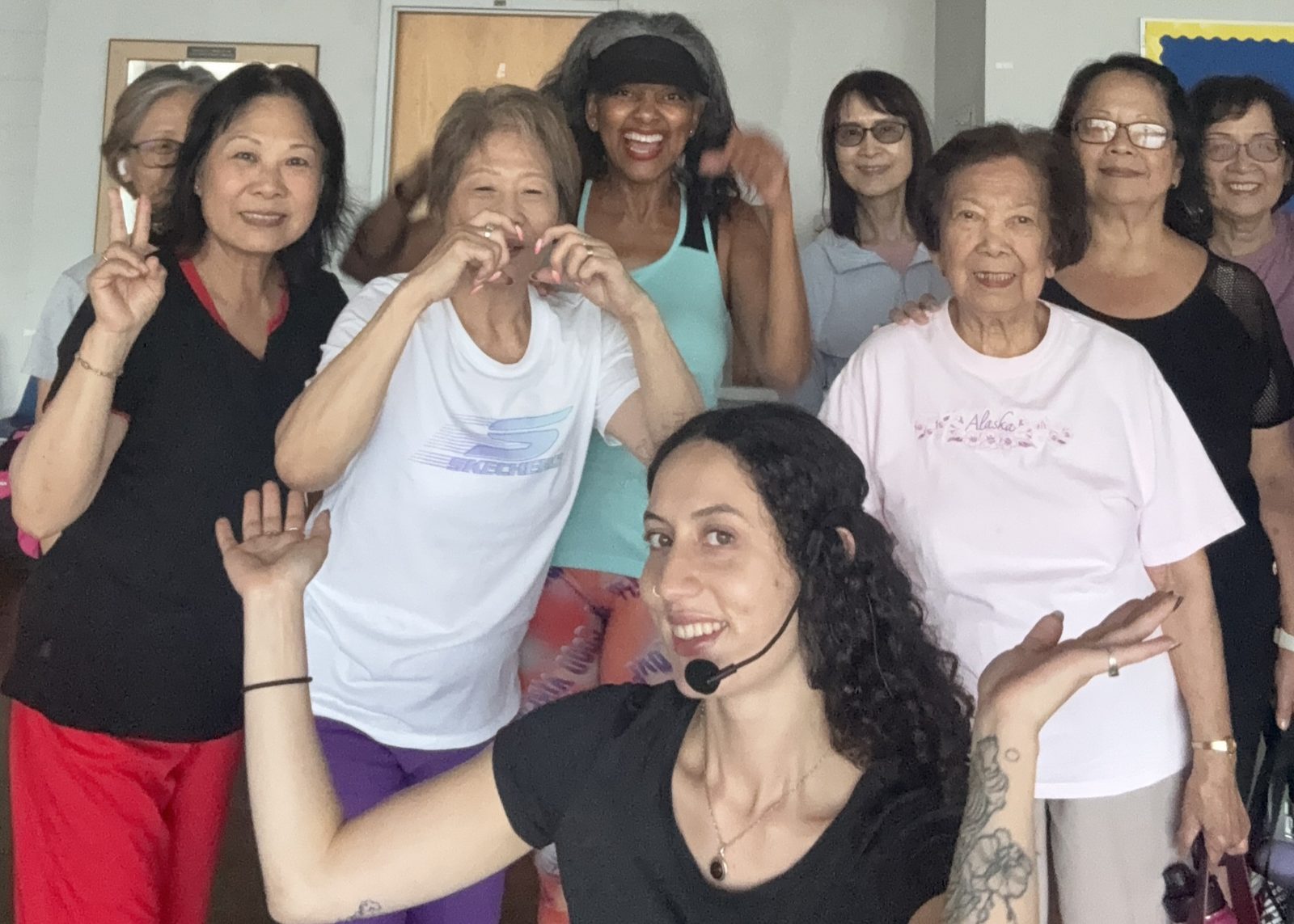 Alli Guzman smiling with a group of older adults after a fitness class in Toronto